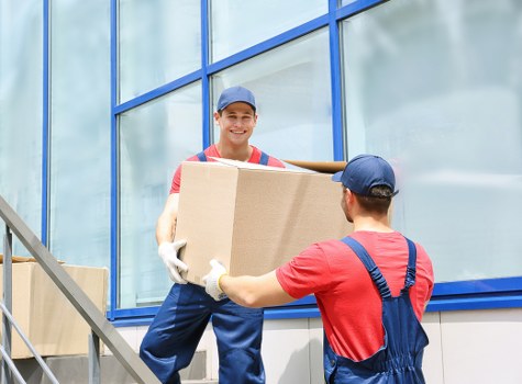 Professional movers wrapping and loading household furniture