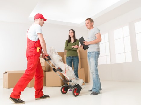 Trained removals staff lifting furniture carefully during a house move